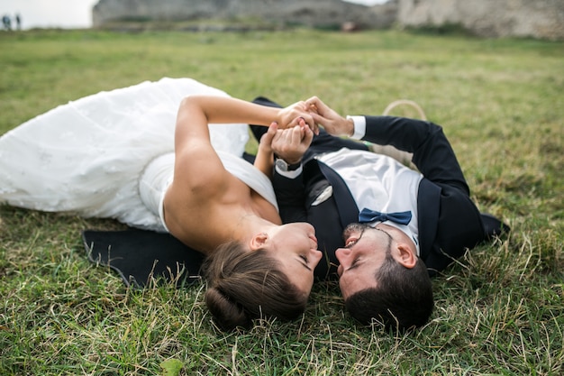 Free Photo young married couple lying on the lawn