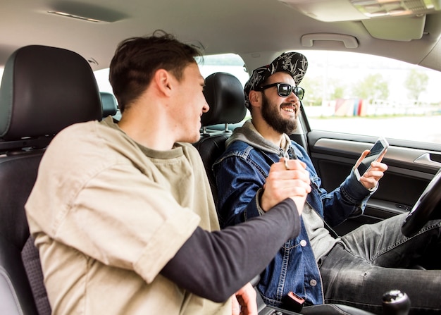 Young men greeting each other in car