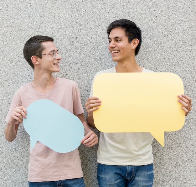 Young men holding speech bubbles