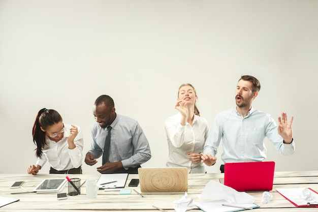 Free photo young men and women sitting at office and working on laptops. emotions concept