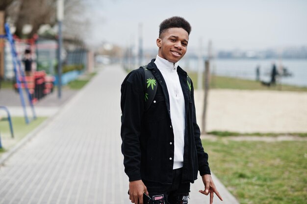 Young millennial african boy walking in city Happy black man with marijuana backpack Generation Z concept