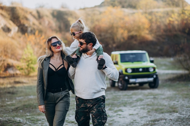 Young modern family travelling by car and stopped for a walk in park