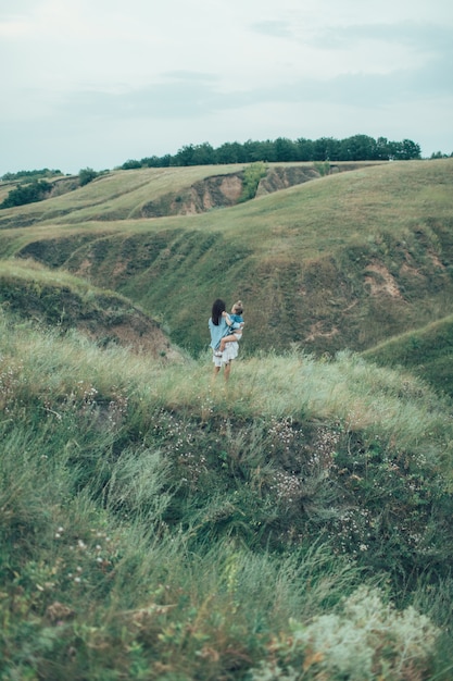 Free Photo the young mother and daughter on green grass space