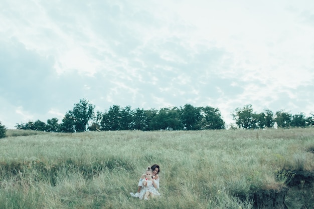 Free Photo the young mother and daughter on green grass