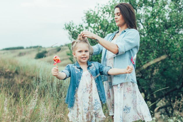 Young mother and daughter on green grass