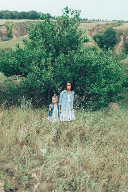 Young mother and daughter on green grass