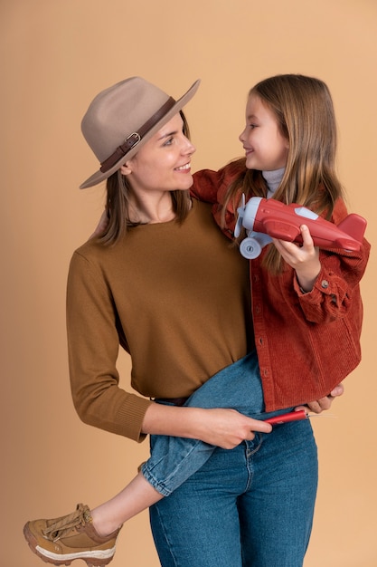 Young mother and daughter posing together before travel vacation