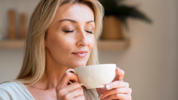 Free photo young mother enjoying the smell of coffee