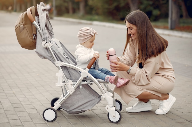 Free photo young mother walking in a autumn park with carriage