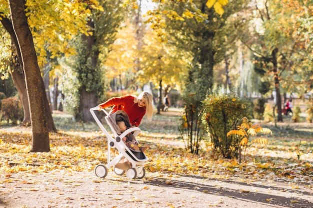 Free Photo young mother with baby daughter walking in park in autumn