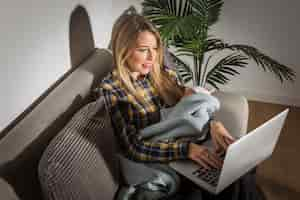 Free photo young mother with baby using laptop on couch