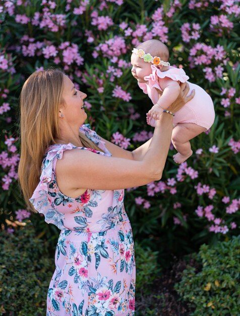 Young mother with a dress with flowers holding her small baby girl