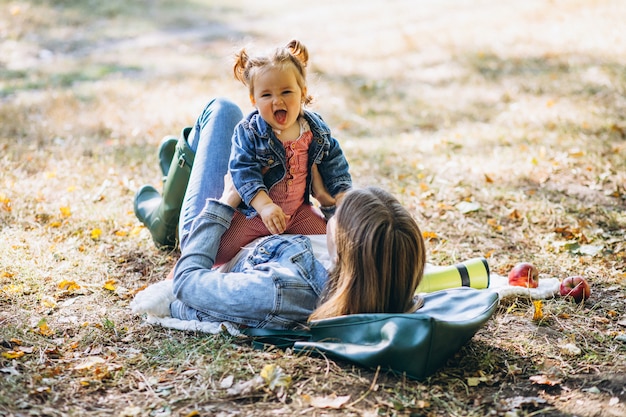 Free Photo young mother with her little daughter in an autumn park having picnic