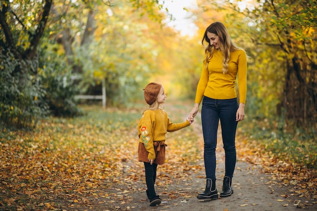 Young mother with her little daughter in an autumn park