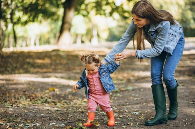 Young mother with her little daughter in an autumn park