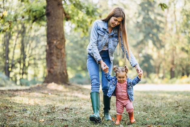 Young mother with her little daughter in an autumn park