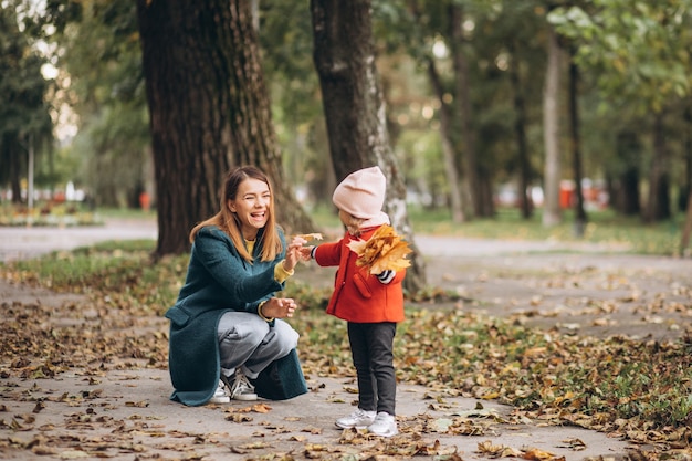 Young mother with her little daughter in an autumn park