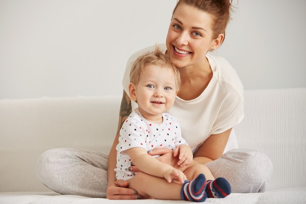 Young mother with her one years old little son dressed in pajamas are relaxing