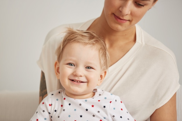 Young mother with her one years old little son dressed in pajamas are relaxing