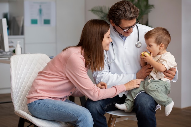 Free photo young mother with her toddler at the pediatrician for a physical examination