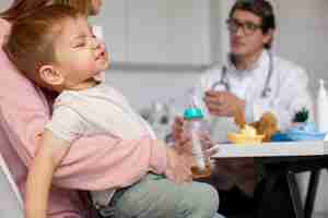 Free photo young mother with toddle at the pediatrician for a consultation