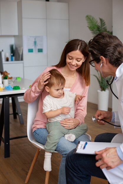 Free photo young mother with toddle at the pediatrician for a consultation