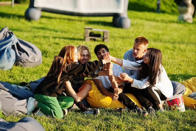 Free photo young multi ethnic group of people watching movie at poof in open air cinema