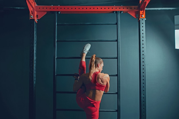 Free Photo young muscular caucasian woman practicing in gym. athletic female model doing strength exercises, training her lower, upper body, stretching.