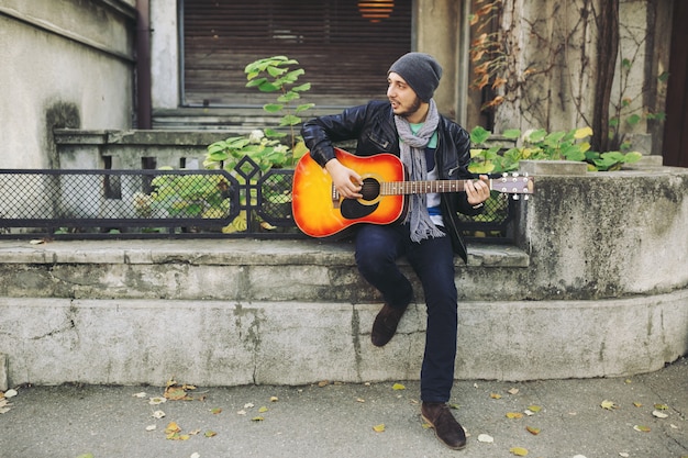 Free Photo young musician with guitar in city