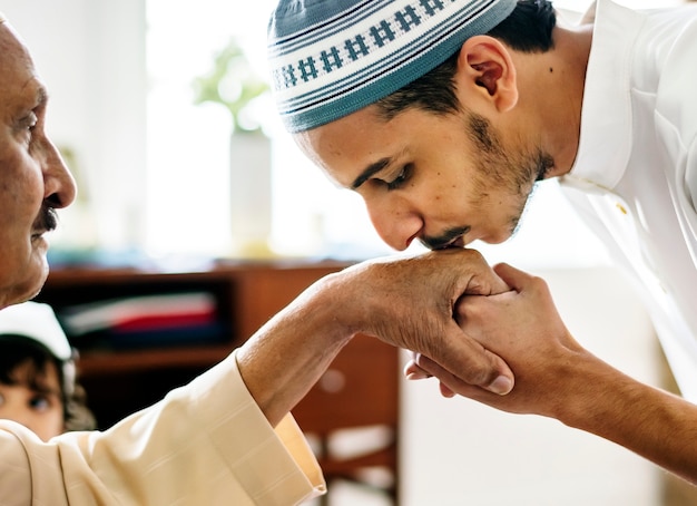 Free Photo young muslim man showing respect to his father