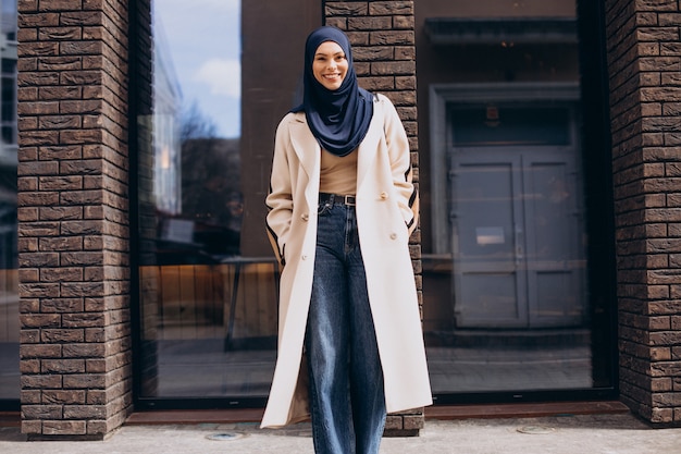 Young muslim woman student walking in the street