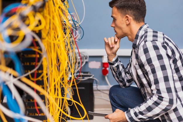 Free Photo young network engineer looking at wires