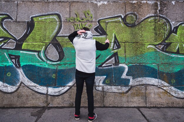 Young painter drawing graffiti on the wall