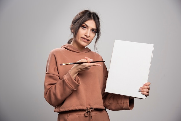 Young painter posing with paint brushes and canvas