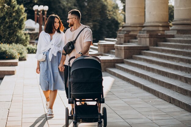 Young parents walking with their baby in a stroller