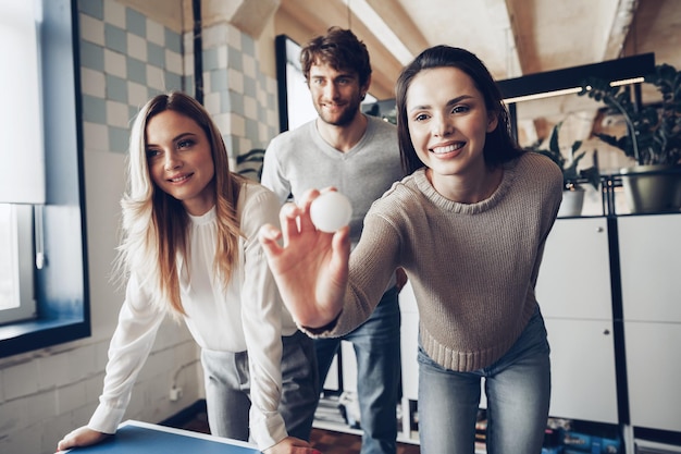 Free photo young people coworkers playing beer pong in modern office