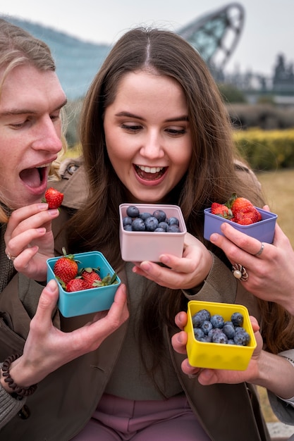 Free photo young people eating berries in the street