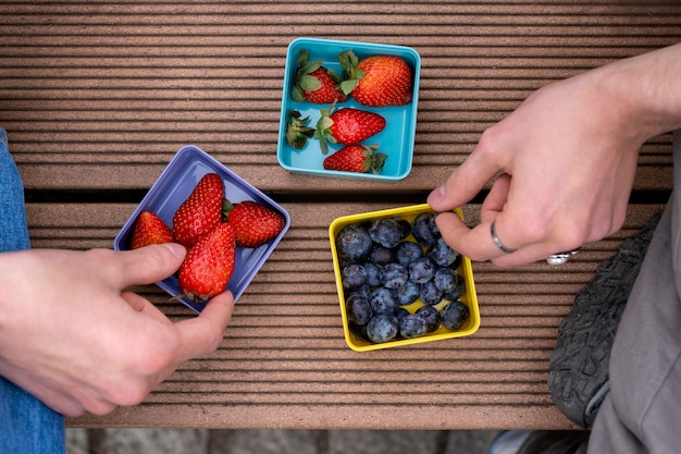 Free photo young people eating berries in the street