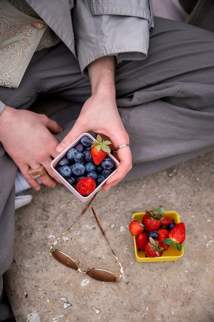 Free photo young people eating berries in the street