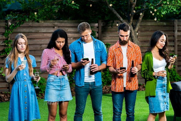 Young people outdoors with phones texting