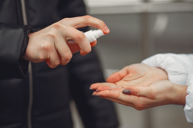 Young people spraying hand sanitizer