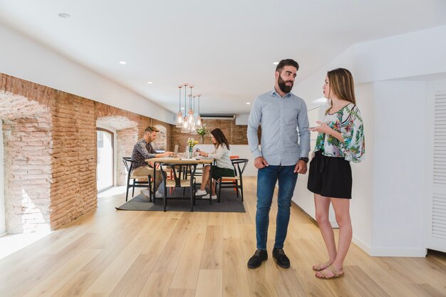 Young people talking on background of coworkers