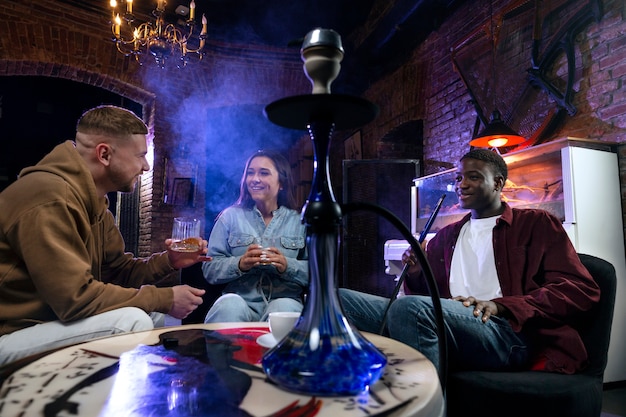 Free Photo young people vaping from a hookah in a bar