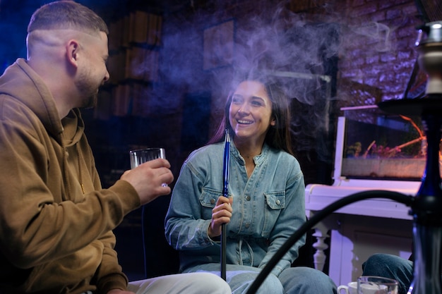 Free Photo young people vaping from a hookah in a bar