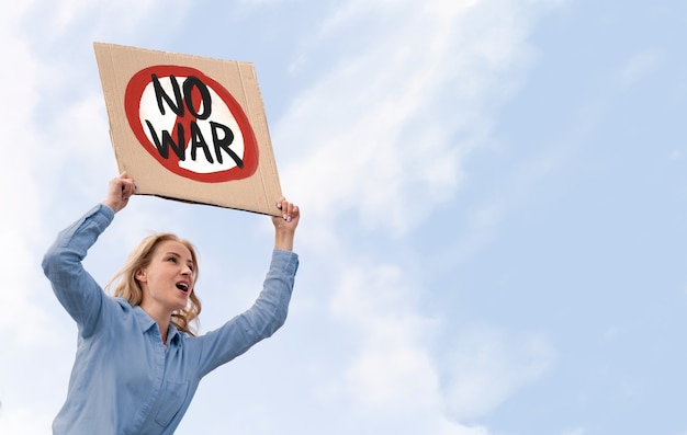 Young person holding anti war protest sign