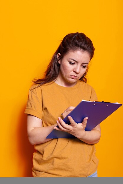 Young person taking notes on notebook files with pen