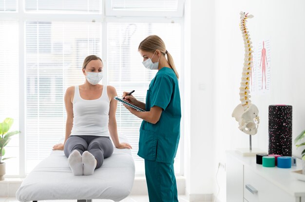 Young physiotherapist helping a patient with back problems