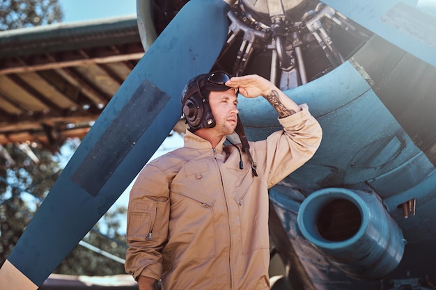 Free photo young pilot is standing near his jet.