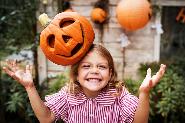 Young playful girl with her Halloween jack lantern