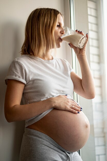 Young pregnant woman drinking milk